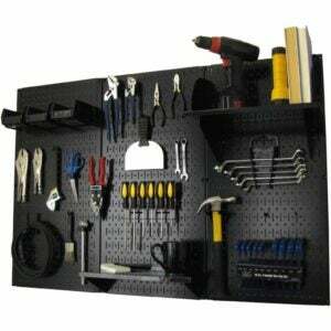 O kit de armazenamento de ferramentas padrão de painel de metal de controle de parede em um fundo branco carregado com ferramentas manuais e elétricas.