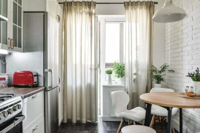 Uma cozinha vazia com cortinas transparentes.