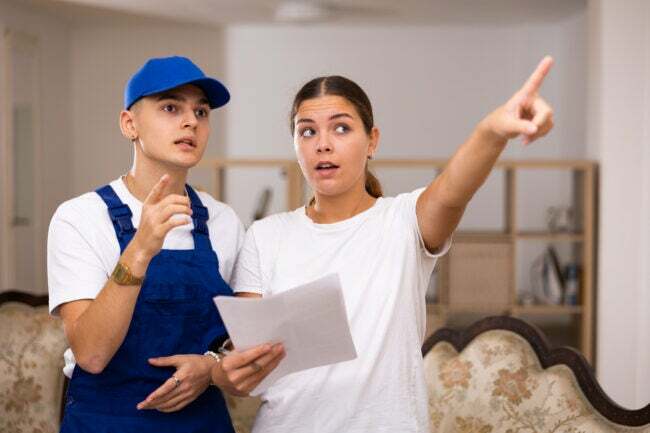 Gospodyni mieszkania wyjaśnia młodemu robotnikowi plan prac remontowych