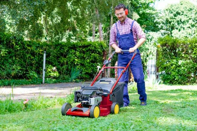 iStock-1261158347 melhorias na casa com reembolso de impostos Retrato de um cara cortando a grama do jardim