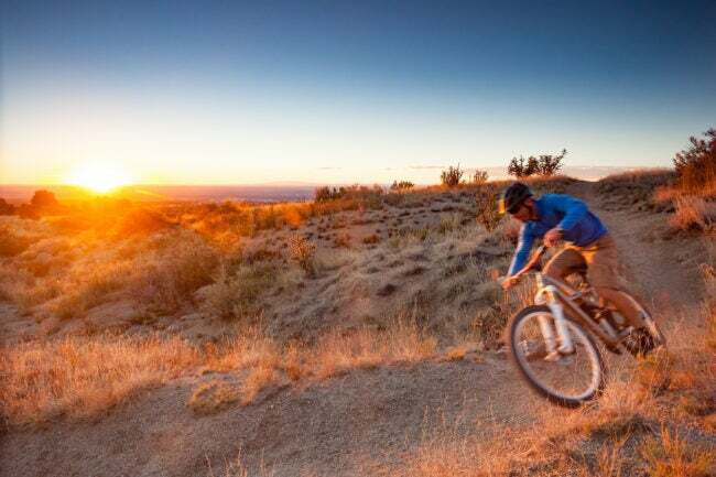 muž jazdiaci na bicykli pri západe slnka neďaleko Albuqurque v Novom Mexiku