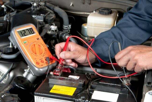 tarefas de manutenção do carro - mãos verificando a bateria do carro