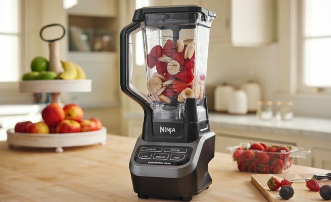 Schwarzer Ninja-Mixer auf der Küchentheke mit Obst im Inneren