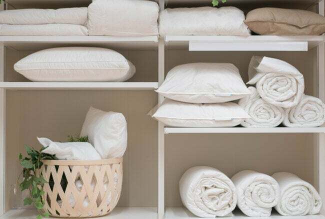 шафа для білизни з подушками на полицях з рушниками чиста білизна