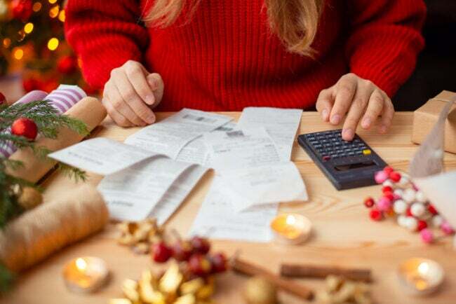 iStock-1434348016 semester shopping kvinna kontrollerar räkningar för julklappar