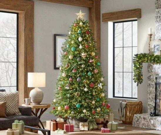 Božično drevo Home Accents Holiday Jackson Noble v praznično okrašeni dnevni sobi.