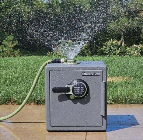 SentrySafe-hjemmesafen gjennomgår en vannbestandighetstest med en sprinkler på