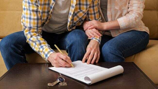 Двойка подписва договор за наем с ключове на масата