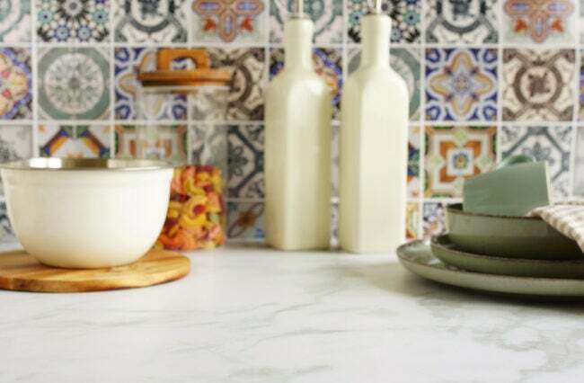 barevná-mozaika-pozadí-přes-bílou-žulu-kuchyňskou desku-s-nádobí