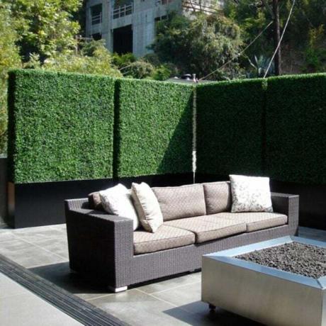 Verdure en faux buis entourant un patio moderne