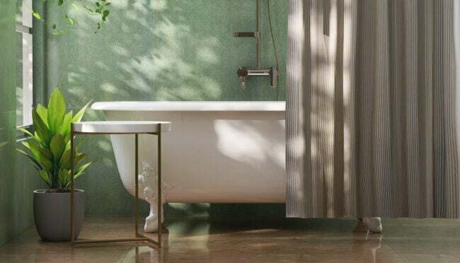 ванна-лапка-на-зеленой-стене-и-частично-скрыта-серой-занавеской для душа