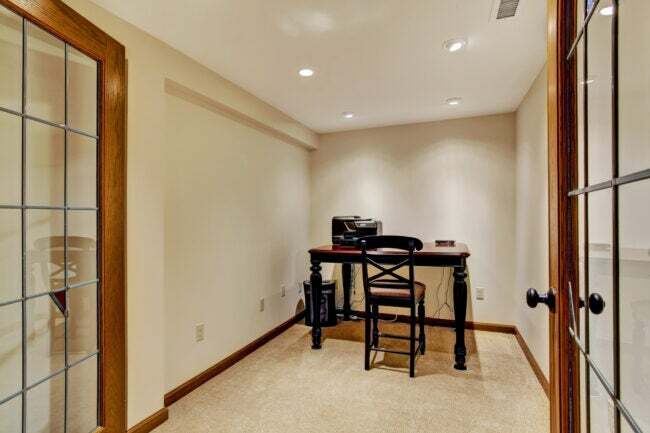 פנים חדר משרד קטן בצבע שנהב רך עם שולחן עבודה וכיסא מעץ