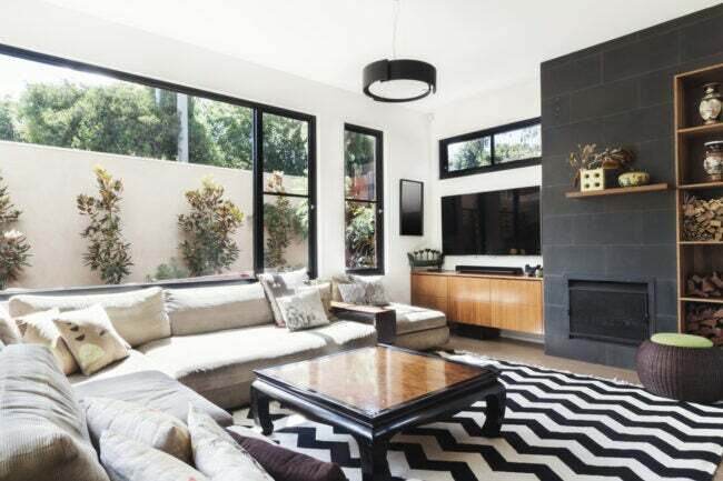 Obývacia izba so svetlými stenami a čiernym lemovaním okien
