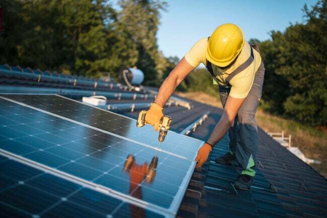 profissionais instalando painéis solares em um telhado