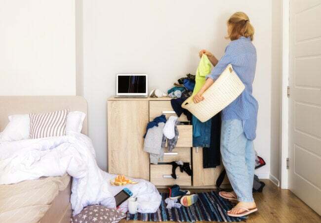 žena vošla do svojej detskej izby s neporiadkom, aby pozbierala špinavé veci a upratala