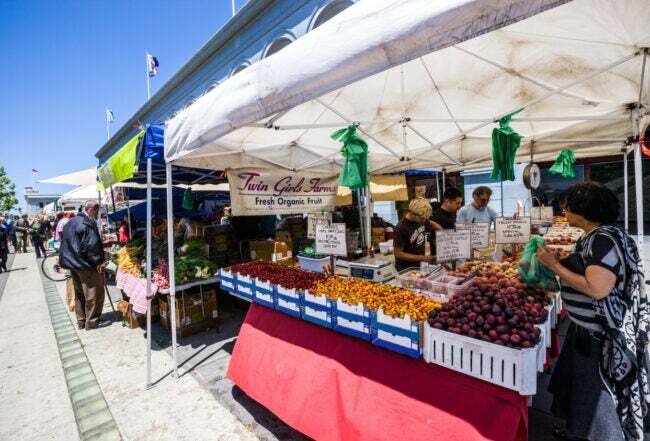 Marché fermier du port de San Francisco, les gens achètent des fruits frais biologiques.