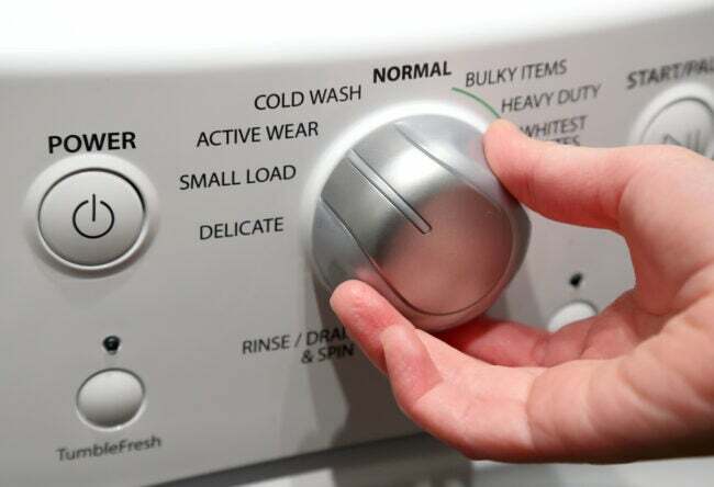 Hånd tænder vaskemaskinen