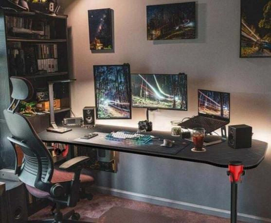 Žaidimų stalas su trimis monitoriais, nešiojamu kompiuteriu ir žaidimų kėde