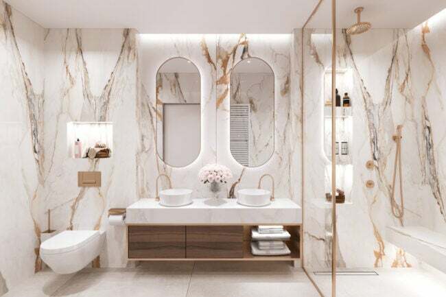 роскошная ванная комната с душевой кабиной, отделанная белым и коричневым мрамором и золотой отделкой