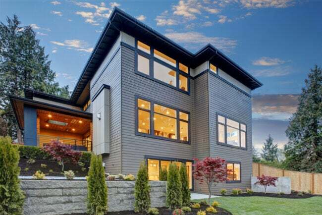 съвременна-къща-с-три-етажна-и-бледо-синя-схема-боядисване-и-озеленяване-срещу-залез-небе