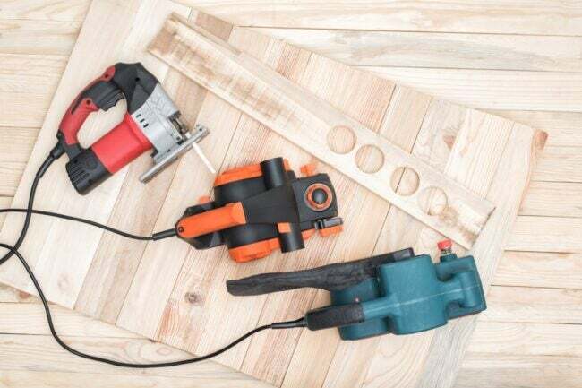 ثلاث أدوات كهربائية تستريح على الخشب الرقائقي
