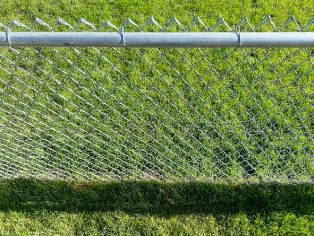 reťazový plot inštalovaný na sviežom zelenom trávniku