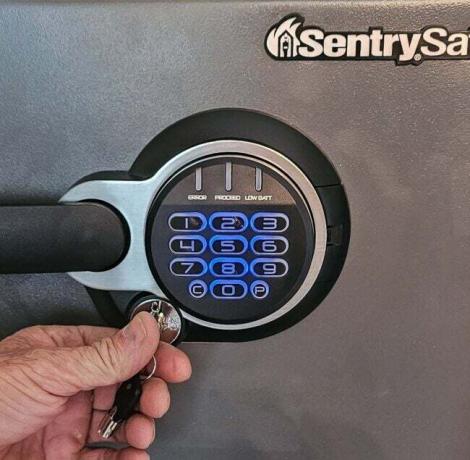 Osoba používající klíč na klávesnici SentrySafe SFW123GDC