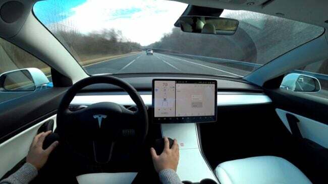 Binnenaanzicht van de bestuurder van een Tesla-auto in automatische pilootmodus