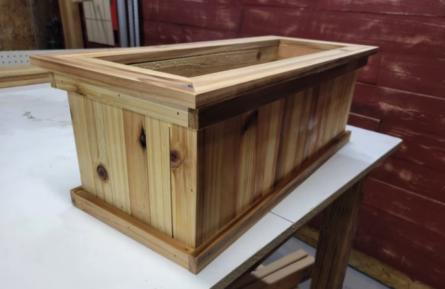 macetero rectangular de madera de cedro encima de mesa de taller