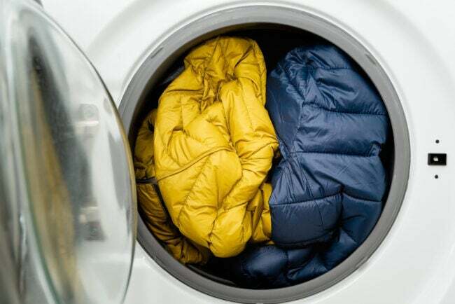 jaquetas azuis e amarelas enfiadas na secadora