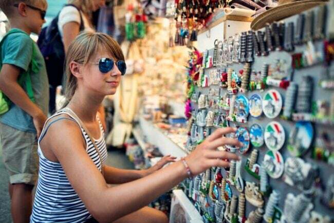 Jong meisje winkelen voor souvenirmagneten