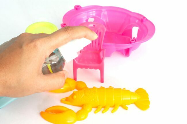 Penyemprotan larutan pembersih pada mainan anak-anak
