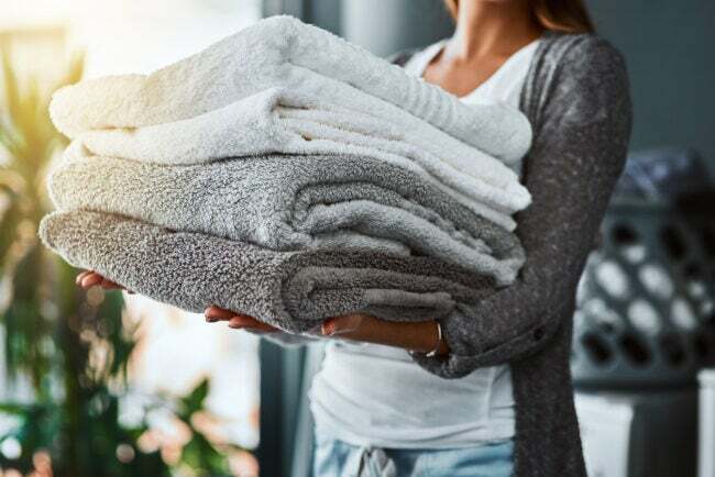 kako koristiti oxiclean žena koja drži složene čiste ručnike