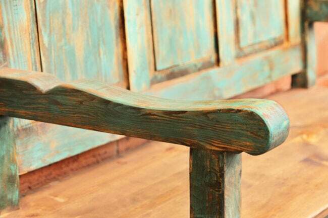 Drevený lavičkový nábytok vyrobený modernými metódami, ale dotvorený tak, aby vyzeral, akoby ho ručne vyrábali mexickí remeselníci z minulej éry. Sedona, Arizona, 2013.