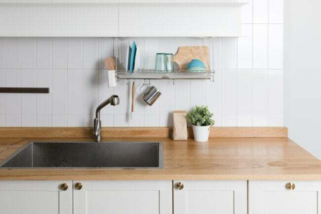 uma bancada de bloco de açougueiro em uma cozinha moderna com armários brancos
