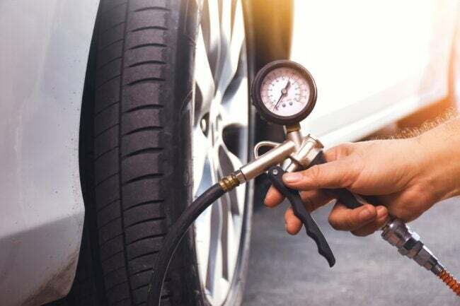 tarefas de manutenção do carro - mão segurando a pressão dos pneus