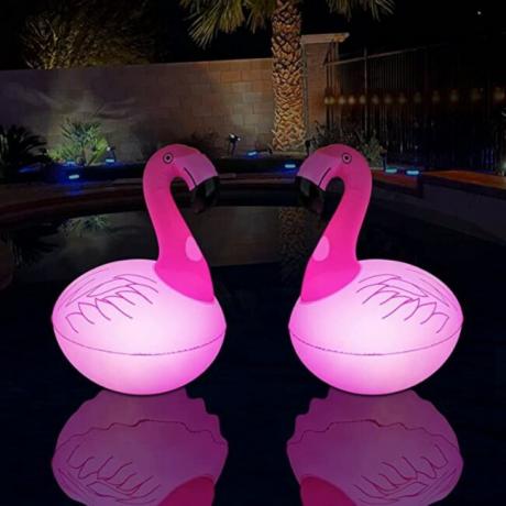 Dva Rukars ružičasta LED flamingo svjetla plutaju noću u bazenu u dvorištu