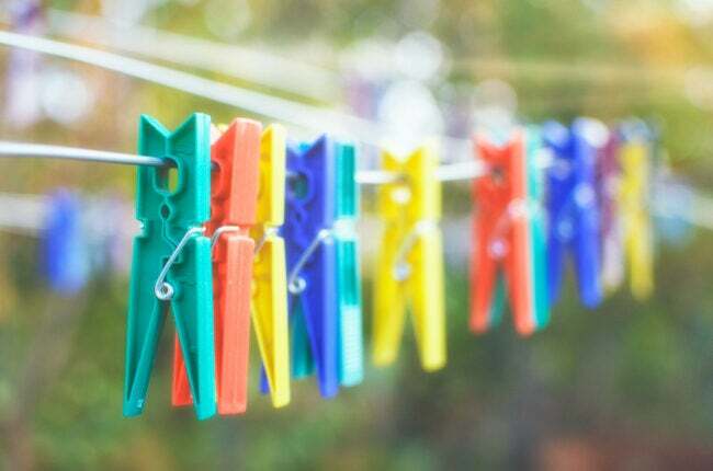 Färgglada klädnypor som hänger i rad på en klädstreck utanför