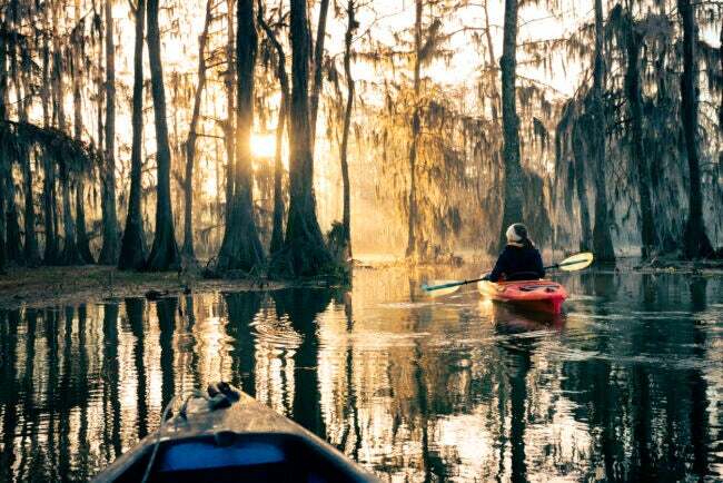 két ember kajakozik egy öbölben Louisianában