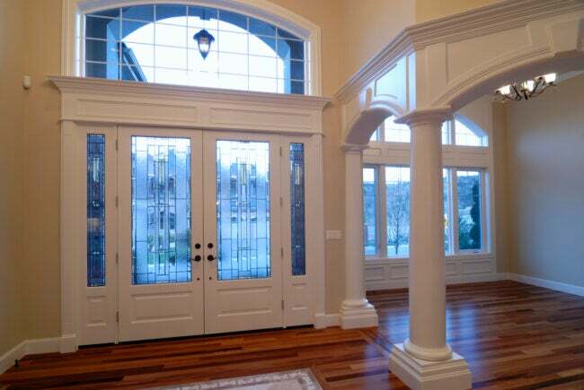 vidinis įėjimas dideliame name su skersiniais langais virš durų ir langų