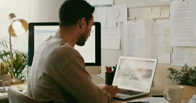 Чоловік дивиться на екран комп’ютера в офісі.