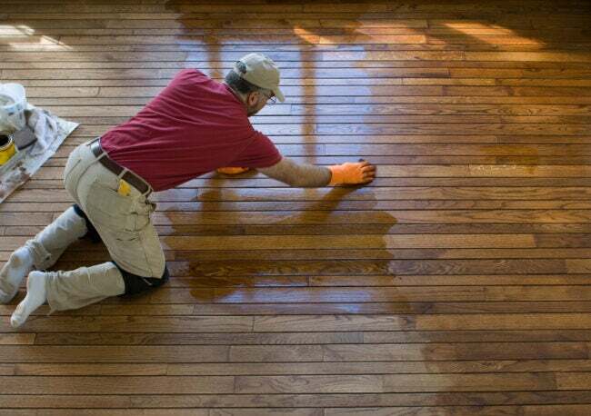 iStock-172925427 възстановяване на данъци Подобрения на дома мъж пребоядисване на дървени подове