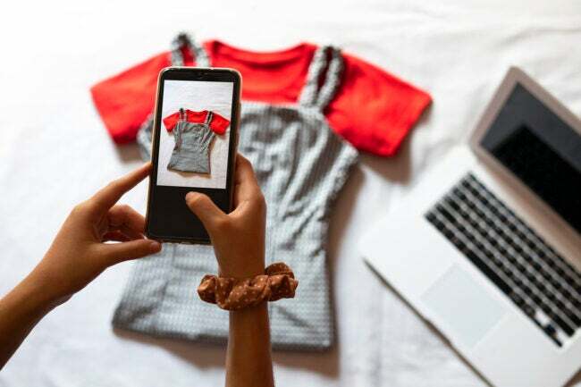 Nő fényképez egy ruhadarabot, hogy eladja az interneten