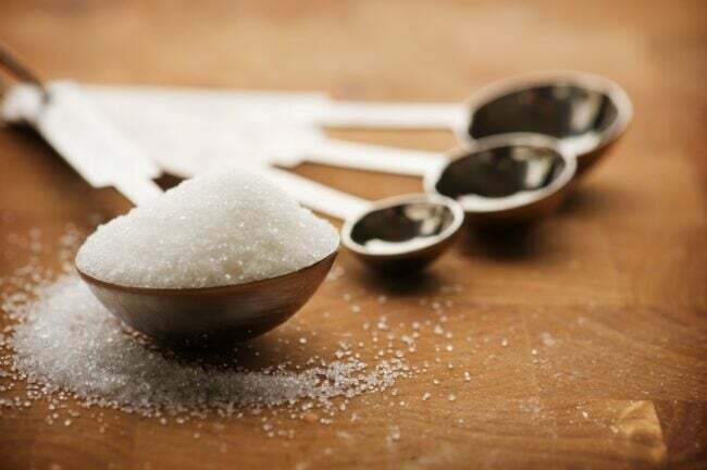 hvitt sukker i måleskjeer