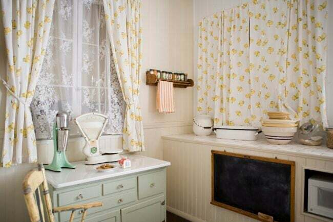黄色いカーテンが付いた小さなコテージキッチン。