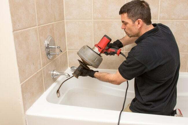 iStock-524026968 як прочистити злив раковини Водопровідник прочищає зливну трубу ванни електричним шнеком