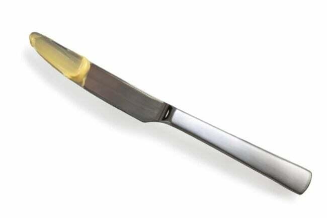 sposoby na wyczyszczenie za i pod każdym urządzeniem - nóż do masła z żółtą substancją