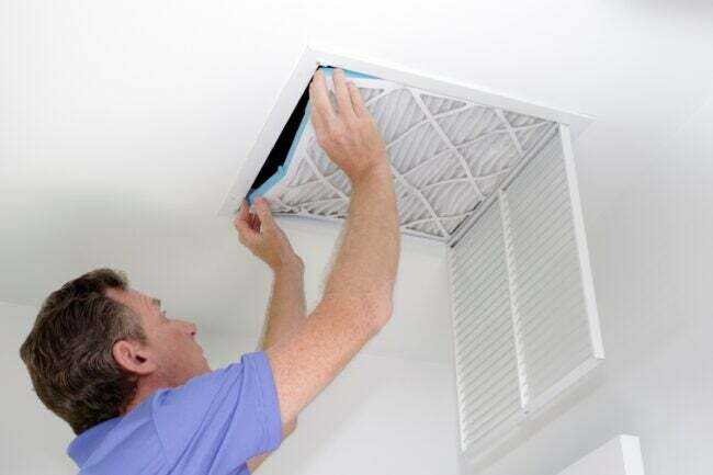 Muž výměna vzduchového filtru na stropě