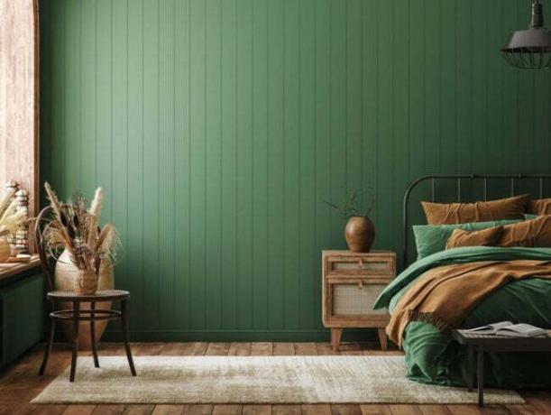 ein grün-braunes Schlafzimmer mit grünen Täfelungs- und Rattanakzenten
