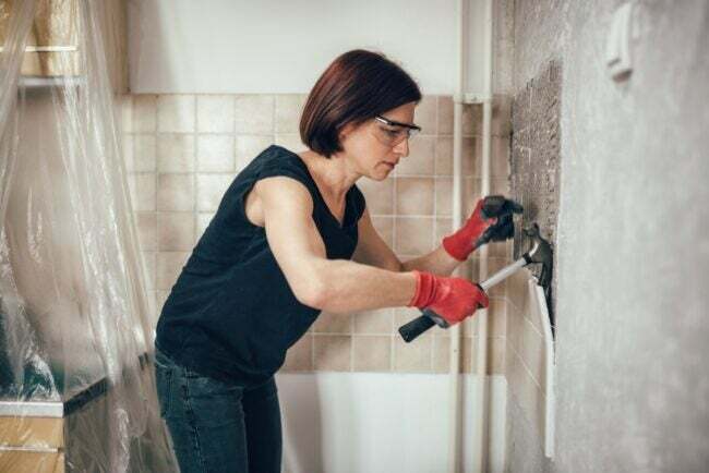 Mulher rasgando o azulejo do banheiro